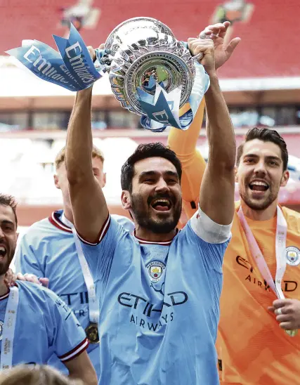  ?? PHOTO: REUTERS ?? Making it his own . . . Manchester City’s Ilkay Gundogan holds the FA Cup aloft after his team beat local rival Manchester United 21 in the final at Wembley Stadium in London yesterday.
