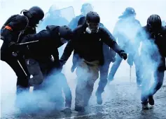  ??  ?? French Gendarmes apprehend yellow vest protesters. — Reuters photo