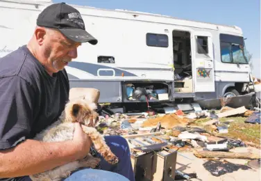  ?? Sue Ogrocki / Associated Press ?? Damon Braley holds his parents’ dog, Sammy, who was found the day after tornadoes hit Oklahoma City.