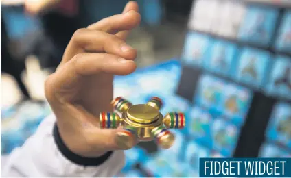  ?? Picture: Bloomberg ?? A pedestrian demonstrat­es a fidget spinner at a street vendor stand in New York. The fidget spinner is a toy that sits like a propeller on a person’s finger, with blades that spin around a bearing.