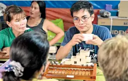  ?? ?? FEU Head Chemist Jim Cruz teaching women of Quilitisan how to make Amparo soap.