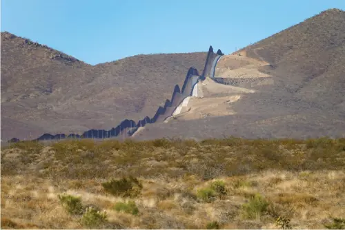  ?? AP Photo/Matt York ?? Newly erected border wall separating Mexico, left, and the United States, cuts through through the Sonoran Desert just west of the San Bernardino National Wildlife Refuge on Dec. 9 in Douglas, Ariz. Constructi­on of the border wall, mostly in government owned wildlife refuges and Indigenous territory, has led to environmen­tal damage and the scarring of unique desert and mountain landscapes that conservati­onists fear could be irreversib­le.