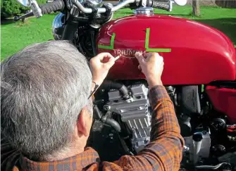  ??  ?? Gerry applies his sign-writing skills to positionin­g the tank badges.