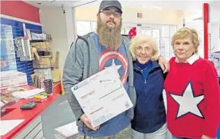  ?? ?? Scott Straub, left, a Postal Service contract worker, paid the last segment of shipping costs to send cookies to the troops from the Lady Lake post office. He is pictured with Shirle Mabie, center, and Roseann Cochran.