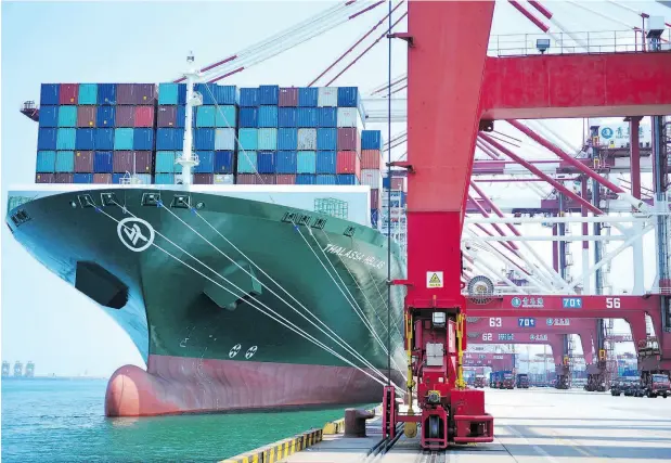  ?? CHINATOPIX / THE ASSOCIATED PRESS ?? A ship is loaded with containers at a port in Qingdao in eastern China earlier this month. The U.S. and China are in an escalating trade war.