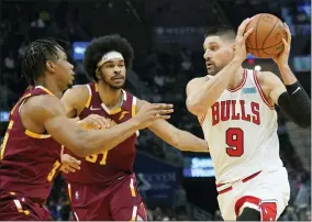  ?? TONY DEJAK - THE ASSOCIATED PRESS ?? Chicago Bulls’ Zach LaVine (8) drives past Cleveland Cavaliers’ Isaac Okoro (35) and Jarrett Allen (31) in the first half of an NBA basketball game, Wednesday, Dec. 8, 2021, in Cleveland.