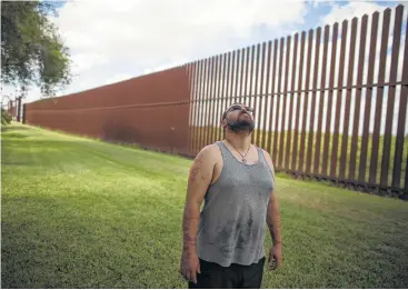  ?? Rodrigo Abd / AP ?? Antonio Reyes, de Brownsvill­e, Texas, mira al cielo frente a la valla que está cerca de su casa y que separa la frontera sur de Estados Unidos con México el 22 de mayo de 2017.