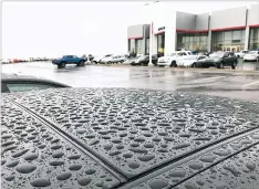  ?? SUSAN MONTOYA BRYAN/THE ASSOCIATED PRESS ?? Raindrops cover cars Wednesday at an auto dealership in Albuquerqu­e. The rain helped to break one of the longest dry spells on record for New Mexico’s largest city.