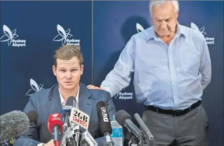  ?? GETTY ?? An emotional Steve Smith is comforted by his father Peter as he fronts the media at Sydney airport on Thursday soon after returning from South Africa.