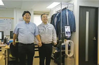  ?? YURI KAGEYAMA/AP ?? Daikyo chief Daisuke Sakurai, left, and General Manager Tomohiko Kojima make a Tiktok video on Aug. 22 in Tokyo.