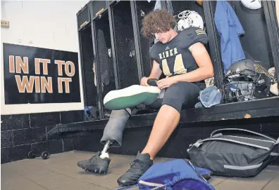  ?? TORIN HALSEY, TIMES RECORD NEWS ?? Colton Ward, a junior at Rider High School, prepares to fit his prosthetic leg for practice.