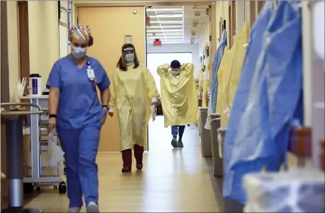  ?? JULIE BENNETT — THE ASSOCIATED PRESS ?? Nurses and medical staff make their way through the seventh floor COVID-19 unit at East Alabama Medical Center in Opelika, Ala., earlier this month. COVID-19 patients occupy most of the beds in the ICU, in addition to the non-critical patients on the seventh floor.