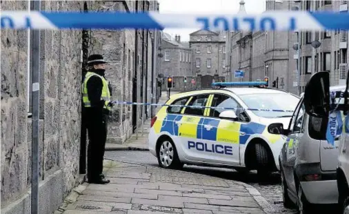  ?? Photograph: Kenny Elrick ?? TRAGEDY: A constable stands guard outside the flats after Mr Clark’s body was found.