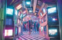  ?? EDDIE MOORE/JOURNAL ?? Christina Procter walks through a tunnel of old television sets at Meow Wolf’s House of Eternal Return, which opened last month in the old Silva Lanes bowling alley.