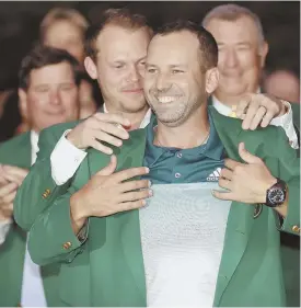  ?? AP PHOTO ?? AT LONG LAST: Sergio Garcia accepts his green jacket from Danny Willett after winning his first career major yesterday at Augusta, Ga.