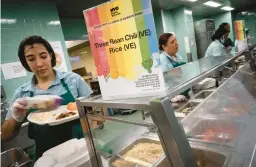  ?? WONG MAYE-E/AP ?? Cafeteria staff serve vegetarian and vegan options to seventh graders during their lunch break at a public school Friday in the Brooklyn borough of New York.