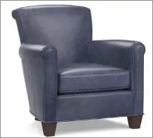  ??  ?? This photo shows Pottery Barn’s Irving roll arm leather armchair. The Irving looks modern in on-trend indigo blue leather.
This undated photo shows Arteriors Warby ottoman. The Warby ottoman comes in a deep blue velvet with gold Deco-inspired accents and would add a chic touch of this inky hue to a living room, dressing room or master suite.