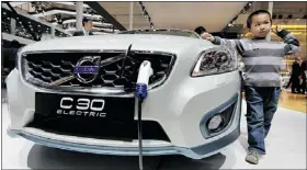  ?? — REUTERS ?? A boy poses next to a Volvo C30 Electric car. Volvo plans to launch 10 new models in China by 2020.