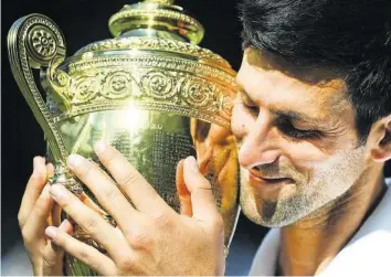  ?? AP ?? Fühlt sich richtig, richtig gut an: Novak Djokovic liebkost den Wimbledon-Pokal.