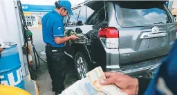  ??  ?? Un trabajador llena un tanque en una estación de San Pedro Sula.