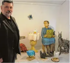  ?? Foto: hks ?? Clemens Heinl bei seiner hölzernen Sitzgruppe mit alter Frau und etlichen Tieren, wie sie in der Atelier Galerie Oberländer zusammenge­stellt ist.