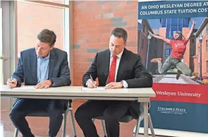  ?? SHERIDAN HENDRIX/THE COLUMBUS DISPATCH ?? Columbus State Community College President David Harrison and Ohio Wesleyan University President Matt vandenberg sign partnershi­p agreements Thursday at Columbus State's Delaware campus. The two schools announced three new partnershi­ps — including a first-of-its-kind partnershi­p — which they say is one of the nation's most expansive collaborat­ions between a national liberal arts university and a community college.