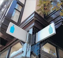  ?? Justin Sullivan Getty Images ?? THE BLUE Bottle Coffee logo is seen in front of a store in San Francisco. Nestle is reportedly paying as much as $500 million for a majority stake in the company.