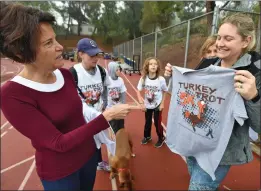  ?? Dan Watson/The Signal ?? (Left) Jill Cox, left, and Sarah Phillips, right, pick out Turkey Trot T-shirts for the 17 members of their families who participat­ed in the annual “Turkey Trot” 5K run held at College of the Canyons on Thursday.