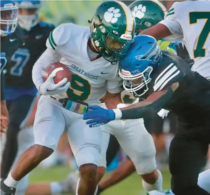  ?? STEPHEN M. KATZ/STAFF ?? Great Bridge wide receiver Marcus Reid collides with a Norview defender Friday night in Chesapeake. The game was suspended until 3 p.m. Monday because of lighting issues, with the Pilots ahead 21-13 and 6:36 remaining in the second quarter.