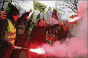  ?? CHRISTOPHE ENA / AP ?? French rail workers use flares during a demonstrat­ion in Paris on Tuesday. French unions plan strikes two days every week through June to protest government plans to eliminate the “cheminot” status that effectivel­y guarantees jobs for life and other...