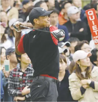  ?? KYODO/VIA REUTERS ?? Tiger Woods watches his tee shot on the sixth hole during final round play Sunday at the ZOZO Championsh­ip near Tokyo. Play was called for darkness with Woods leading by three strokes.