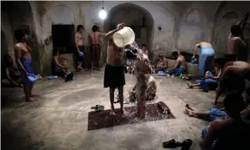  ?? ?? Men and boys at a hammam in Herat, Afghanista­n. As well as providing washing facilities lacking in most homes, they allow Islamic ritual cleaning to take place. Photograph: Majid Saeedi/Getty