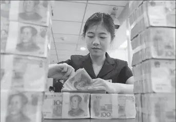  ?? LI GUOCHAO / FOR CHINA DAILY ?? A bank clerk at a Bank of China branch in Nanchong, Sichuan province. Many small Chinese investors are turning their backs on low interest savings accounts and moving their money into online funds.