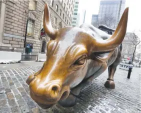  ?? AP PHOTO/RICHARD DREW ?? The Charging Bull sculpture by Arturo Di Modica, in New York's Financial District, is shown in this photo. The current bull market is set to turn nine years old in about a month. As of Jan. 26, the date of the last market record, the S&P 500 had more...