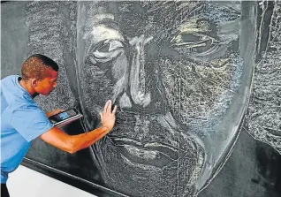  ?? Picture: IVOR MARKMAN ?? FINE WORK: NMU fine art student Logan Ramage works carefully on his drawing of Nelson Mandela. Three NMU students were at Baywest Mall yesterday afternoon to create chalk drawings in honour of Madiba's birthday next week.