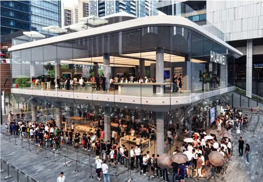  ?? AFP ?? Experts say Moscow’s welcome of Huawei does not mean the Chinese company is alone in the race for developing 5G in Russia. People queue outside a newly opened Huawei flagship store in Shenzhen in China’s southern Guangdong province.