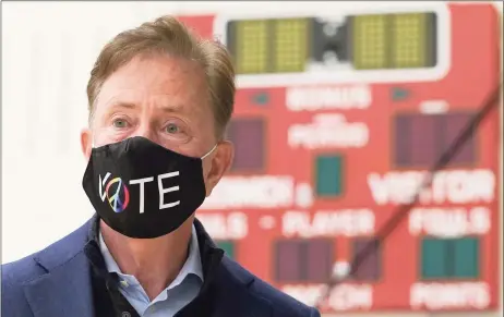  ?? Timothy A. Clary / AFP via Getty Images ?? Gov. Ned Lamont prepares to cast his vote at Greenwich High School on Election Day 2020. Lamont, citing the need to attack COVID-19, has proposed a state budget including a 2 percent spending increase in the fiscal year that starts July 1.