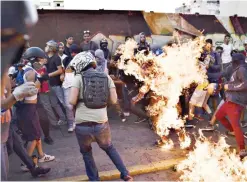  ??  ?? CARACAS: This photo taken on May 20, 2017 shows opposition demonstrat­ors setting an alleged thief on fire during a protest against the government of President Nicolas Maduro. — AFP