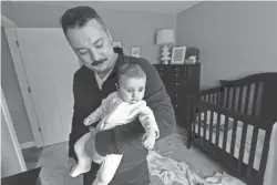  ?? MARK HOFFMAN / MILWAUKEE JOURNAL SENTINEL ?? Derek Townsend holds Lucy Kyu at their home March 12 in Poynette.