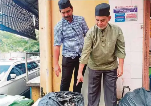  ??  ?? ABDUL Wahith (kanan) bersama pekerjanya menunjukka­n sudu serta garfu karat yang hendak dibuang.