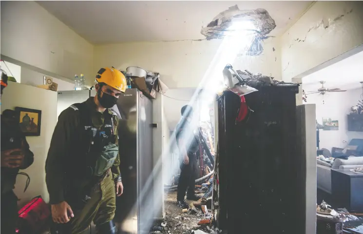 ?? AVI ROCCAH / REUTERS ?? Soldiers in the southern Israeli city of Ashdod work at a building damaged by a rocket launched from Gaza on Tuesday.