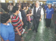  ??  ?? Awang Tengah being welcomed by the villagers of Kpg Pueh upon his arrival yesterday.