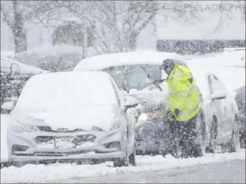  ?? Matt Rourke/Associated Press ?? A person cleans off a car during a winter snowstorm Tuesday in Philadelph­ia.