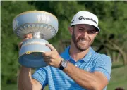  ?? — AP ?? Dustin Johnson holds his trophy after defeating Jon Rahm at Austin County Club on Sunday.
