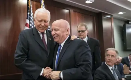  ?? J. SCOTT APPLEWHITE — ASSOCIATED PRESS ?? House Ways and Means Committee Chairman Kevin Brady, R-Texas, center, shakes hands with Senate Finance Committee Chairman Orrin Hatch, R-Utah, Wednesday on Capitol Hill after House and Senate GOP leaders announced they had reached an agreement on a...