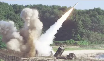  ?? — AFP photo ?? This handout photo provided by South Korean Defence Ministry in Seoul shows US M270 Multiple Launch Rocket System firing an MGM-140 Army Tactical Missile into the East Sea from an undisclose­d location on South Korea’s east coast during a South Korea-US...