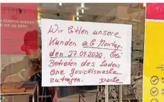  ??  ?? Viele Händler in der Stadt haben Bitten und Regeln an die Eingangstü­ren angeschlag­en.