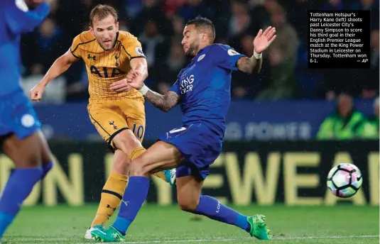  ?? — AP ?? Tottenham Hotspur’s Harry Kane (left) shoots past Leicester City’s Danny Simpson to score his third goal in their English Premier League match at the King Power Stadium in Leicester on Thursday. Tottenham won 6-1.