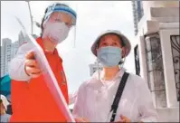  ?? JIANG KEHONG / XINHUA ?? Zuzana Pavlonova (left) from the Czech Republic works as a volunteer to guide a resident through nucleic acid testing in Xiamen, Fujian province, in September.
