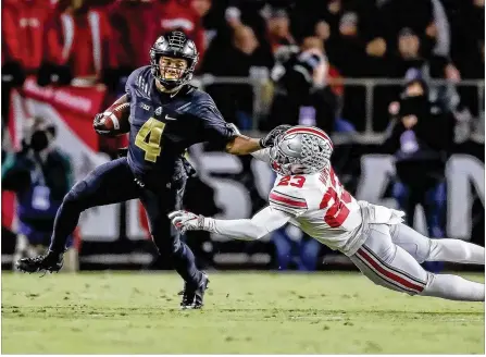  ?? MICHAEL HICKEY / GETTY IMAGES ?? Purdue freshman wide receiver Rondale Moore fights off OSU sophomore safety Jahsen Wint during the Boilermake­rs’ 49-20 victory. Moore caught 12 passes for 170 yards and two TDs, and had two carries for 24 yards. Wint finished with two tackles.